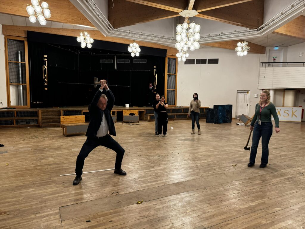 Inspektor Carl Johan Sundberg inleder renoveringen av aulan med ett första släggslag (december 2023)